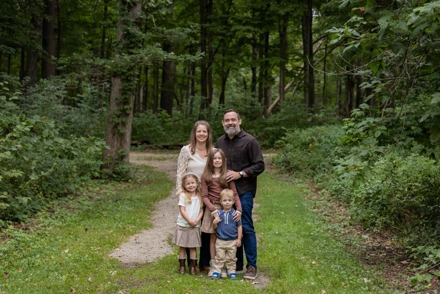 The Greens, a family of five standing together on a forest path
