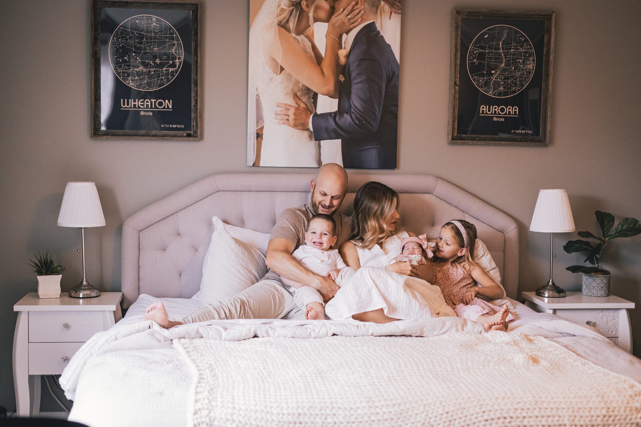 The Simeks, a family of five on a bed in warm light
