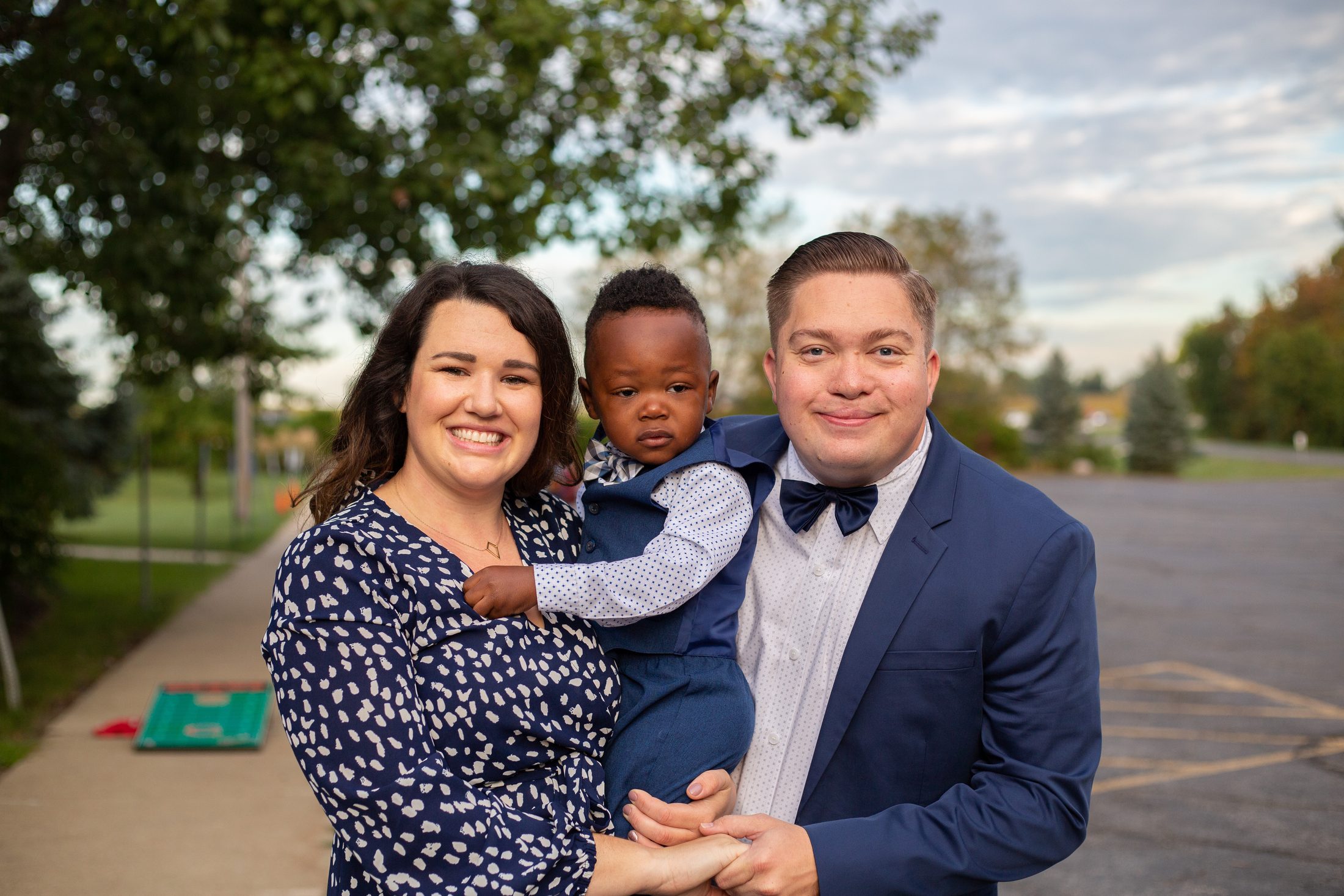 Jordan's adoption day, his parents holding him outdoors