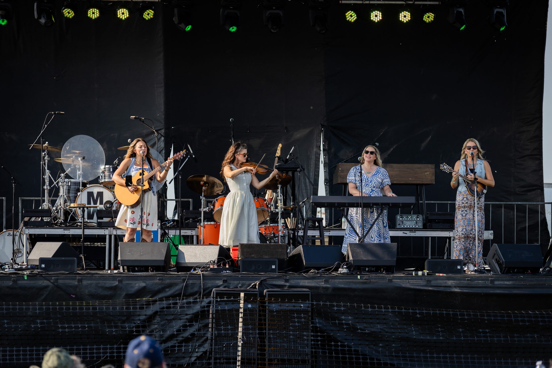 Helmarpalooza 2025, a band of four women performing on an outdoor stage